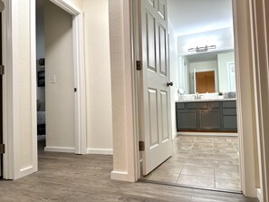Enter a stylish kitchen with a large mirror above the sink and modern grey cabinets.