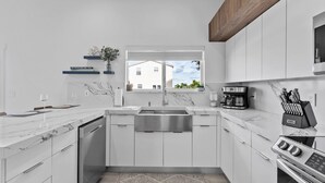 A modern kitchen with white cabinets, a stainless steel sink, and a built-in oven. - Waterfront, 4Br/3B Home, 5 min from John Pennekamp State Park (Key Largo)