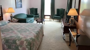 A hotel room with a bed, two green armchairs, a small table, a dresser, and two lamps. - Rollo Bay Inn (Rollo Bay)