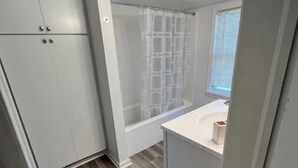 A bathroom with a shower, a toilet, and a sink. - Beautifully Renovated, Luxury Home in Beachwood OH (Beachwood)