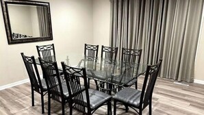 A dining area with a glass table surrounded by six chairs with cushioned seats and backs. - Beautifully Renovated, Luxury Home in Beachwood OH (Beachwood)