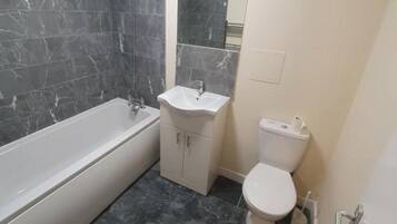 Ein Badezimmer mit Badewanne, Waschbecken und Toilette.