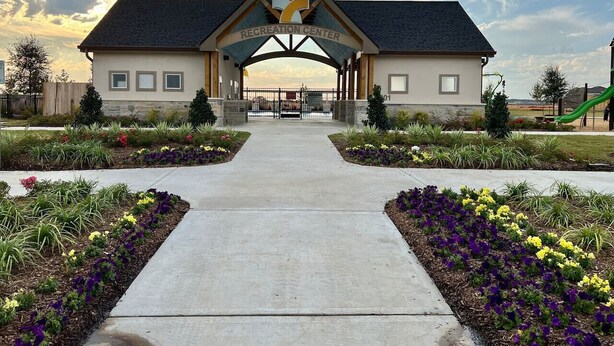 A recreation center with a central entrance, surrounded by flower beds and a clear sky. - 4 BR Cheerful Home Long Term Stay Equipped in Katy (Katy)