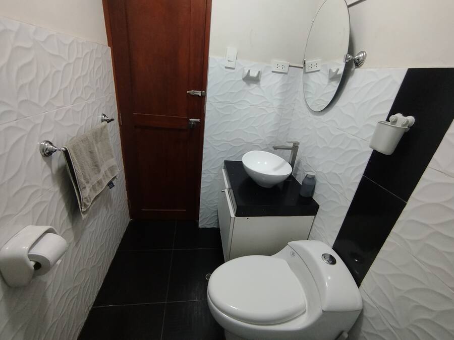 Une petite salle de bain comprenant des toilettes, un lavabo et un porte-serviettes.