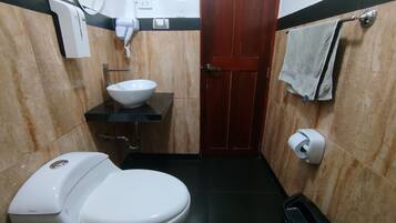 Un bagno compatto con il water, un lavandino e un porta asciugamani.