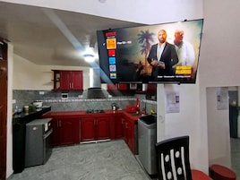 Una cocina con un televisor montado en la pared mostrando la interfaz de Netflix.