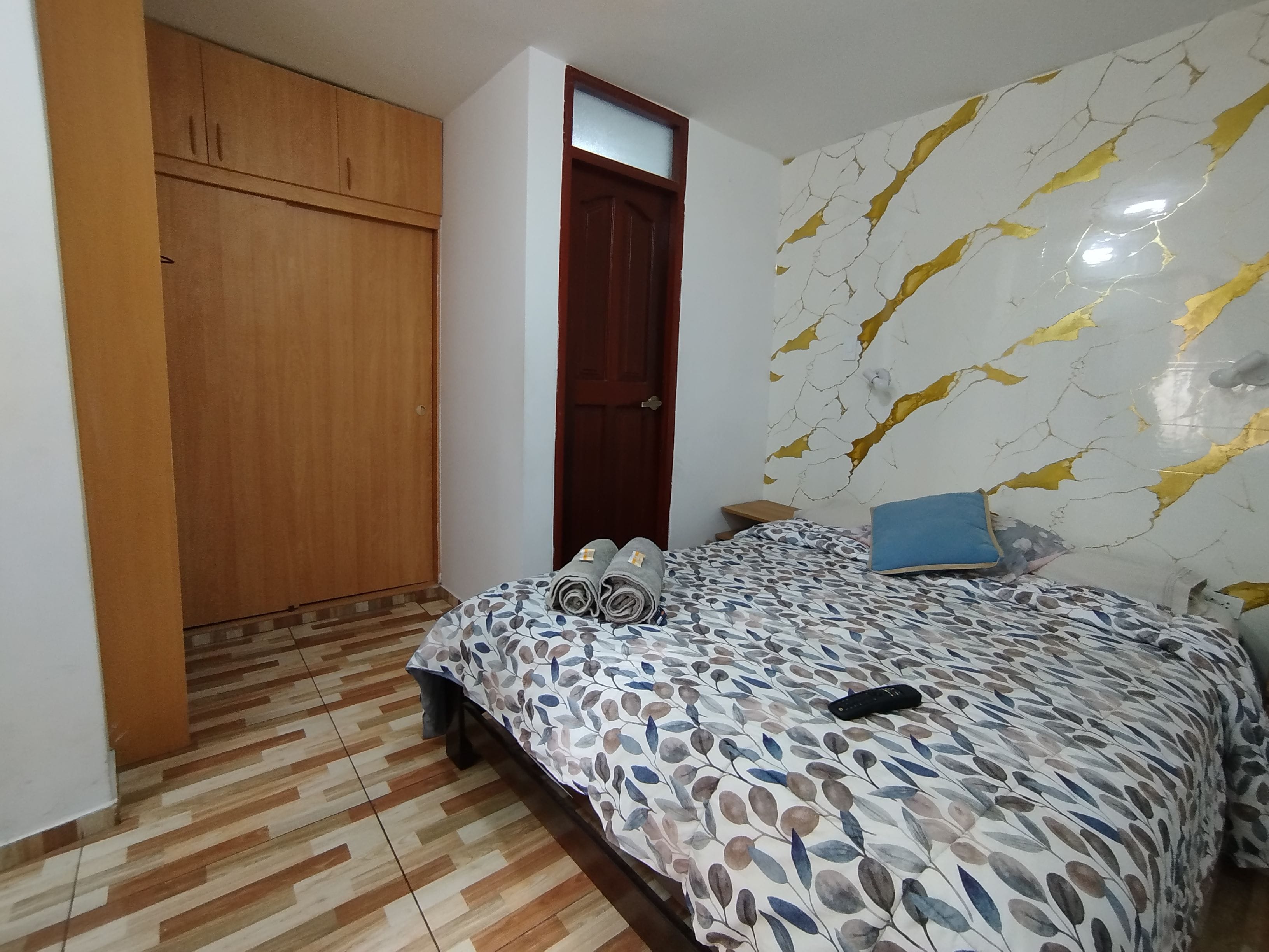 Une chambre à coucher avec un lit, une armoire et une porte.