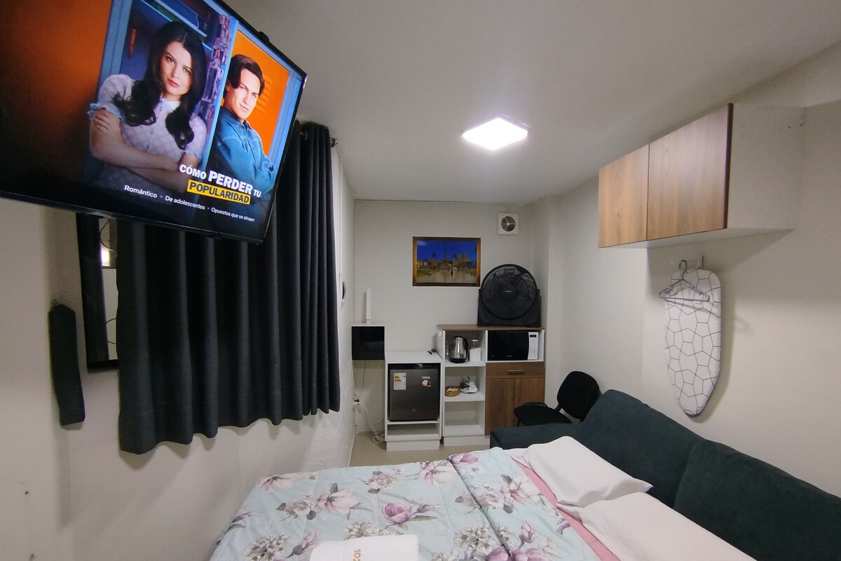 Makuuhuoneessa on sänky, televisio, työpöytä, tuuletin ja mikroaaltouuni.