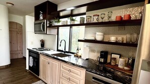 A modern kitchen with wooden cabinets, stainless steel appliances, and a built-in oven.