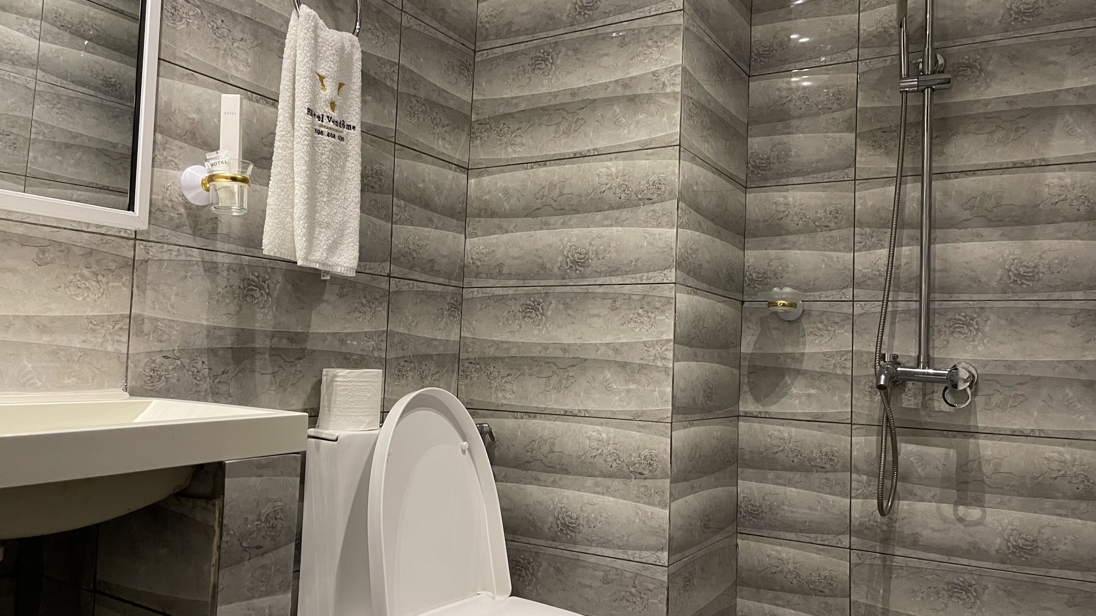 A modern bathroom with a shower, toilet, and sink.
