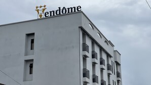 A building with a sign reading "Vendôme" and a modern architectural style with balconies.