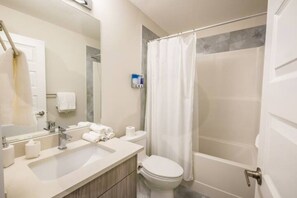 A modern bathroom with a sink, toilet, and shower.