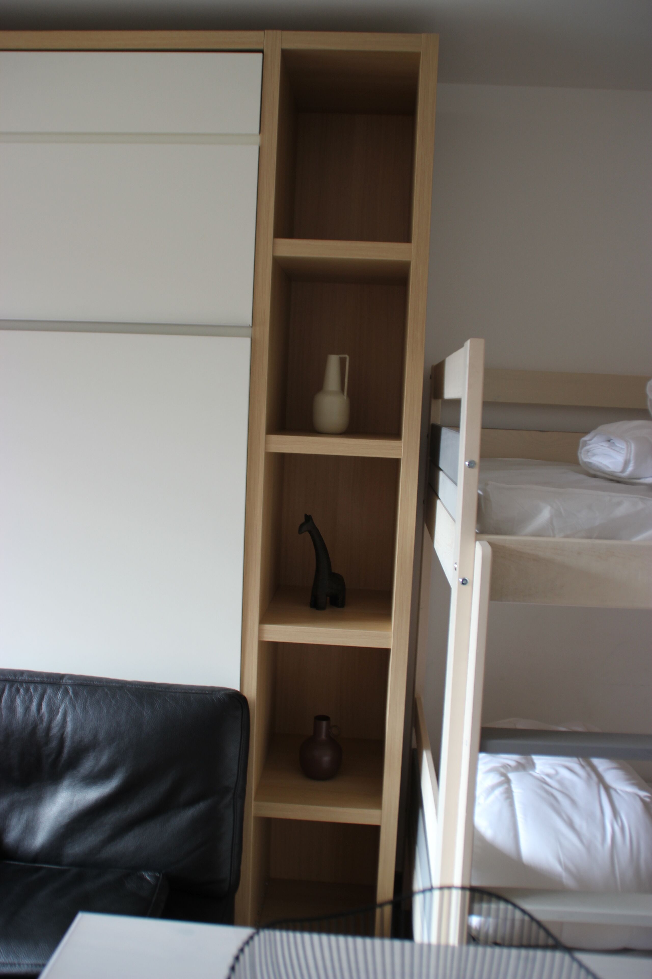 Une chambre avec un lit superposé, un bureau avec une chaise et une armoire.