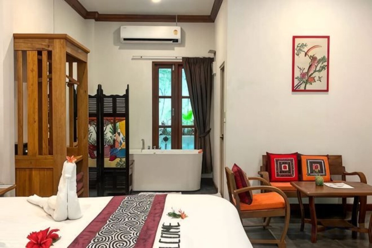 Habitación de hotel con cama, escritorio, silla, bañera y ventana.