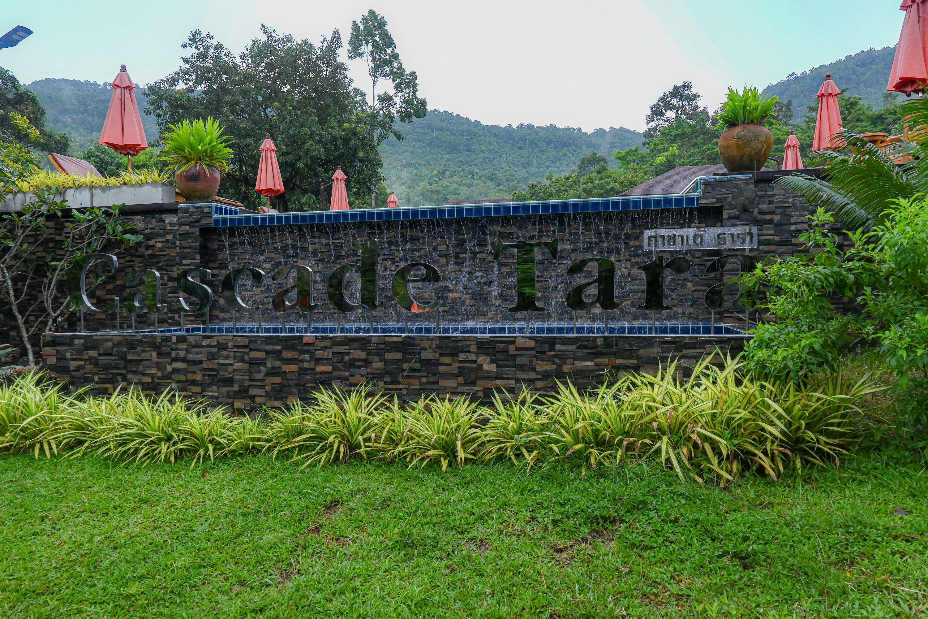 A stone wall with the text "Cascade Terrace" and potted plants.