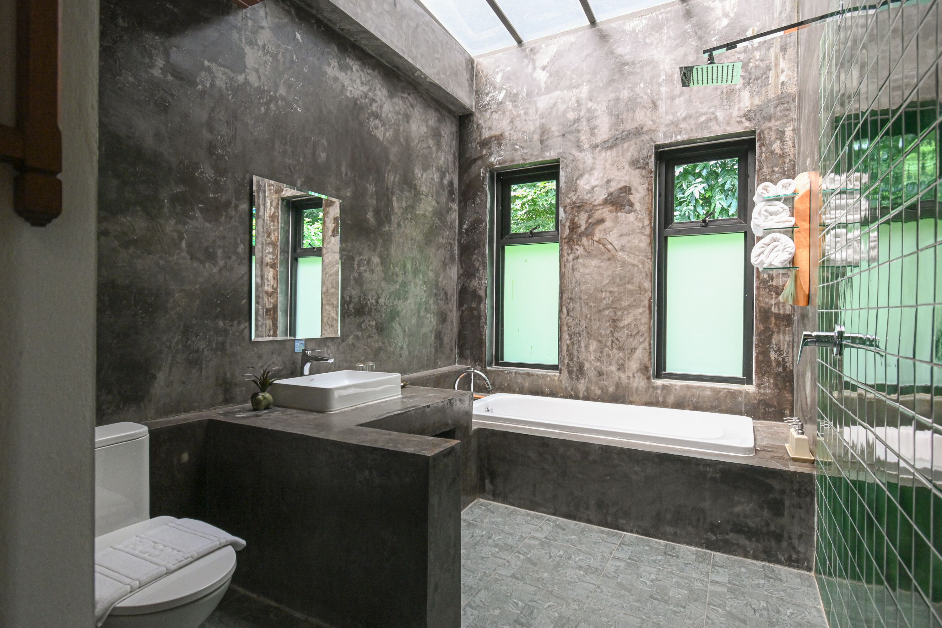 A modern bathroom with a bathtub, a sink, and a toilet.