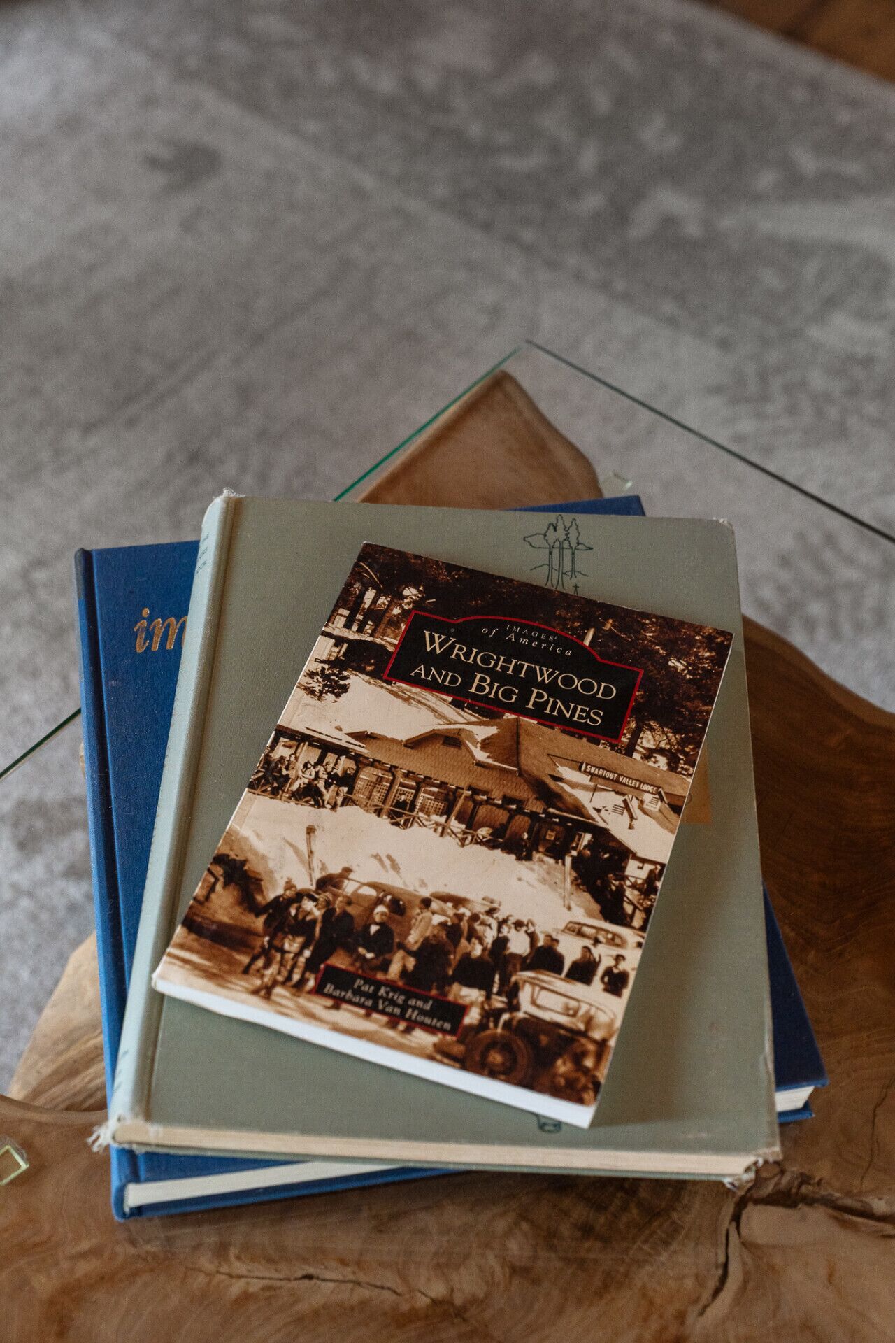 Una pila de libros, uno de ellos con el título 'Wrightwood and Big Pines', sobre una superficie de madera.