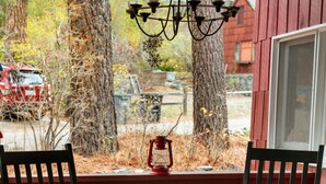A round outdoor fire pit with a metal table in front, surrounded by wooden chairs. - Rustic Retreat|Pets OK, Near Village, Fireplace (Wrightwood)