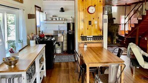 Een gezellige keuken met houten kastjes, een eettafel en een klok aan de muur.