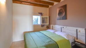 A bedroom with a bed, a nightstand, a window, and a wall-mounted picture. - Pet friendly apartment in Longare (Longare)