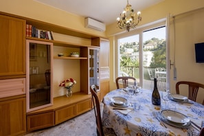 A dining area with a table set for four, a chandelier, and a view of the outside.