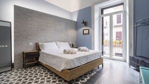 A bedroom with a bed, a nightstand, a wardrobe, and a view of the outside. - GuestHost - Cozy apartment equipped with all comforts and able to accommodate up to 4 people. The flat is located in a very central position: we are in fact a 10-minute walk from Piazza Maria Immacolata, just over 15 minutes from the Archaeological Museu (Taranto)