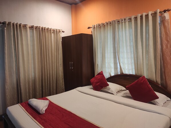 Une chambre d’hôtel avec un lit, une armoire et des rideaux.