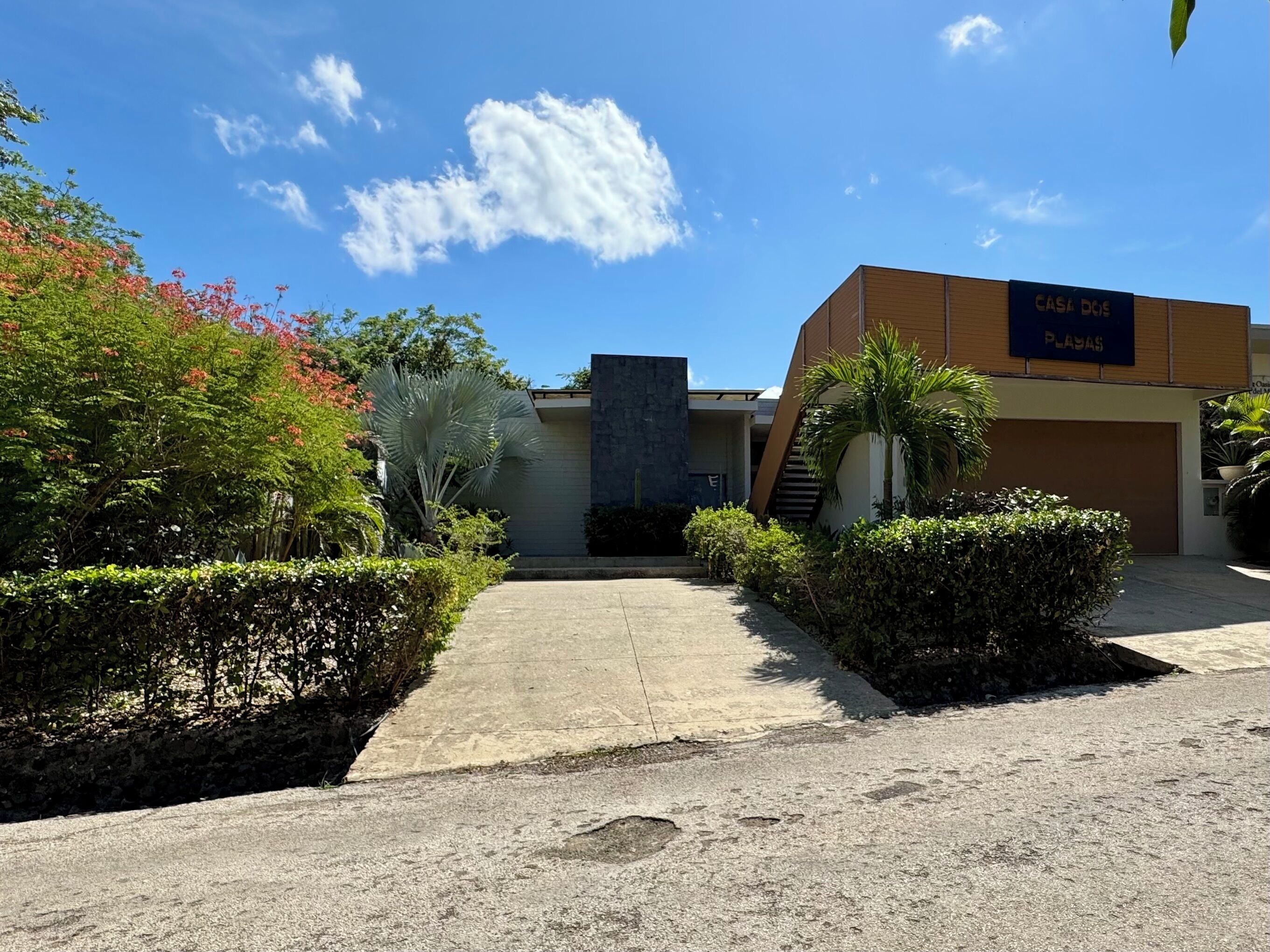 Un edificio con un cartello che riporta 'CASA DOCE PLASAS' e un vialetto lastricato che conduce all'ingresso.