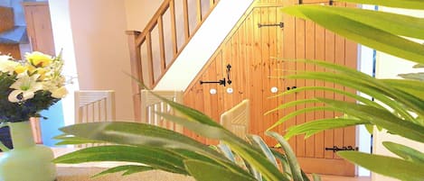 Una escalera con barandillas de madera y una puerta con picaporte negro.