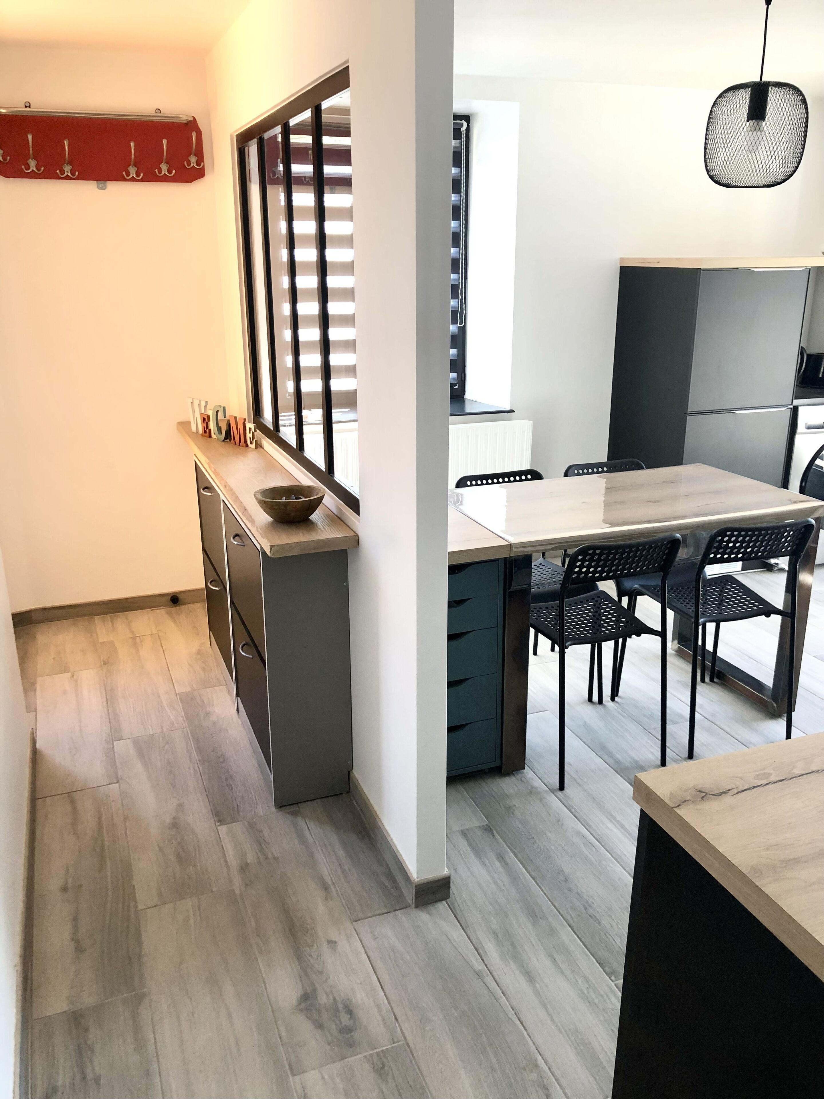 Una cocina moderna con encimera de madera, una zona de comedor con mesa y sillas, y un horno empotrado.