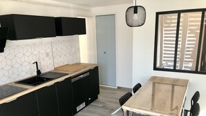 Una cucina moderna con mobili neri, un piano di lavoro in legno e una lavastoviglie.