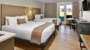 A hotel room with two beds, a desk, a chair, and a television. - The Inn at Aspen (Aspen)