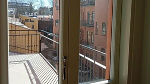 Una puerta con vista a un balcón y un edificio al otro lado de la calle.