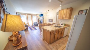 A kitchen with wooden cabinets, a central island with a sink, and a refrigerator.