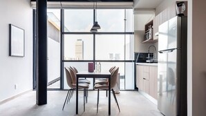A modern kitchen with a large window, a dining table with chairs, and a stainless steel refrigerator. - w* | Splendid Loft with Terrace near Polanco (Ciudad de México)