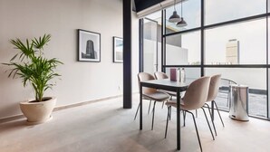 A modern office space with a large window, a potted plant, and a table with chairs. - w* | Splendid Loft with Terrace near Polanco (Ciudad de México)
