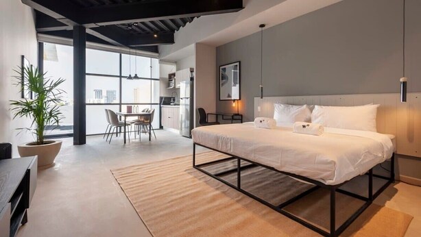 A modern bedroom with a large bed, a dining area, and a view of the city. - w* | Splendid Loft with Terrace near Polanco (Ciudad de México)