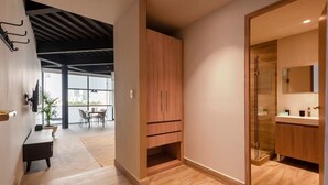 A modern interior with a wooden floor, a dining area with chairs and a table, a wooden cabinet, and a glass shower enclosure. - w* | Splendid Loft with Terrace near Polanco (Ciudad de México)