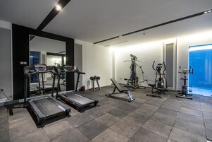 A modern gym with treadmills, dumbbells, and weight machines.