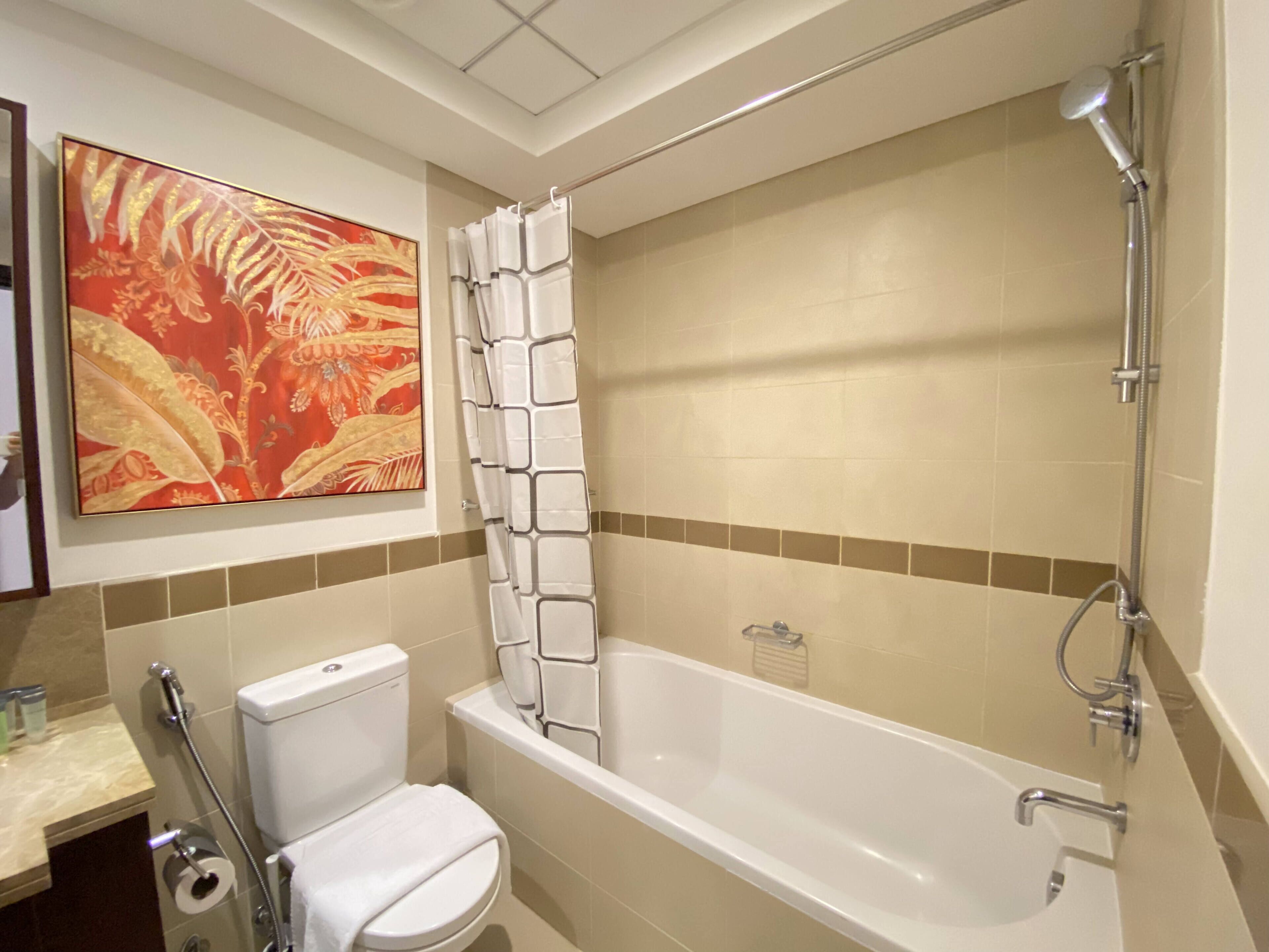 A bathroom with a bathtub, toilet, and shower.