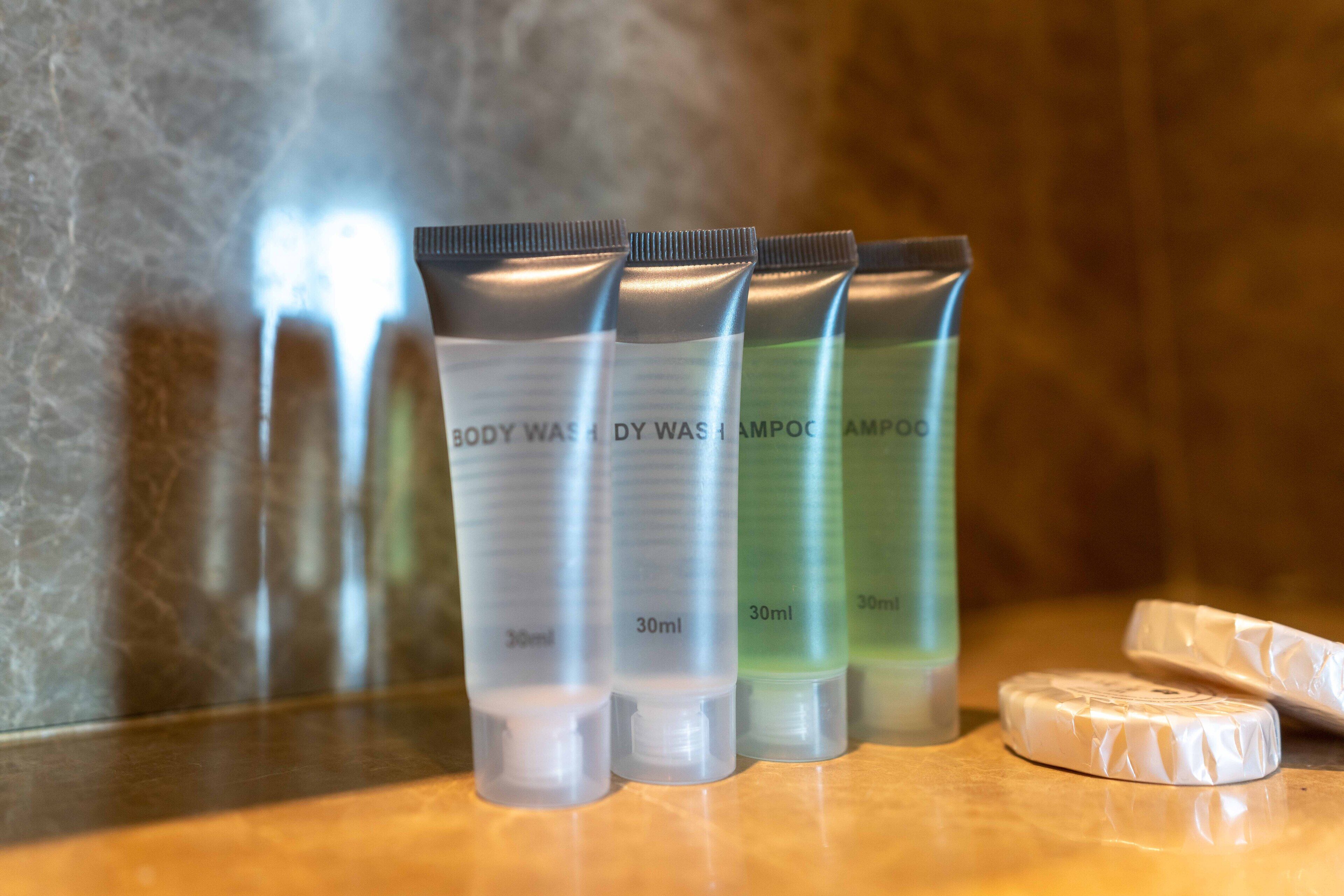 Four 30ml tubes of body wash and shampoo on a marble surface.