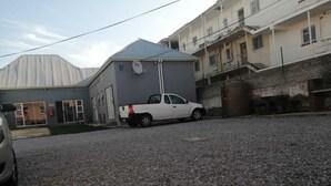 A gravel driveway with a white pickup truck parked on the side. - monument pavilion (Gqeberha (Port Elizabeth))