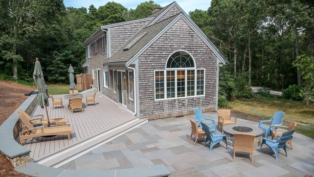 A house with a deck, outdoor seating, and a fire pit. - Sprawling Home With Great Outdoor Space (2288) (Harwich Port)