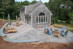 A house with a deck, outdoor seating, and a fire pit. - Sprawling Home With Great Outdoor Space (2288) (Harwich Port)