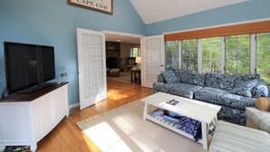 A living room with a television, sofa, and coffee table. - Sprawling Home With Great Outdoor Space (2288) (Harwich Port)