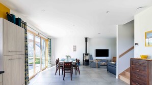 Een moderne woonkamer met een eethoek, een open haard en een televisie.