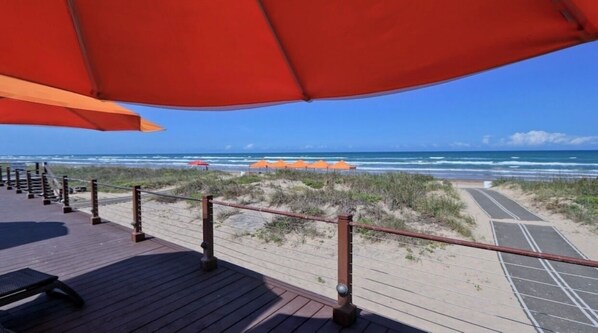 Walk along the boardwalk to the beach, where umbrellas and chairs await.
