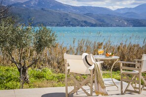 Een tafel buiten, met uitzicht op een meer en bergen.