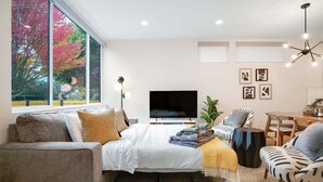 Ett modernt vardagsrum med en soffa, ett soffbord, en tv och en matplats.