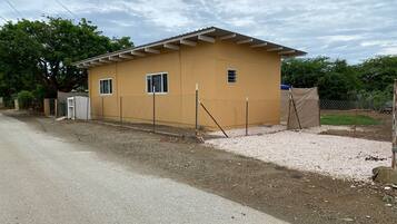 A small, single-story building with a flat roof and a fenced perimeter.